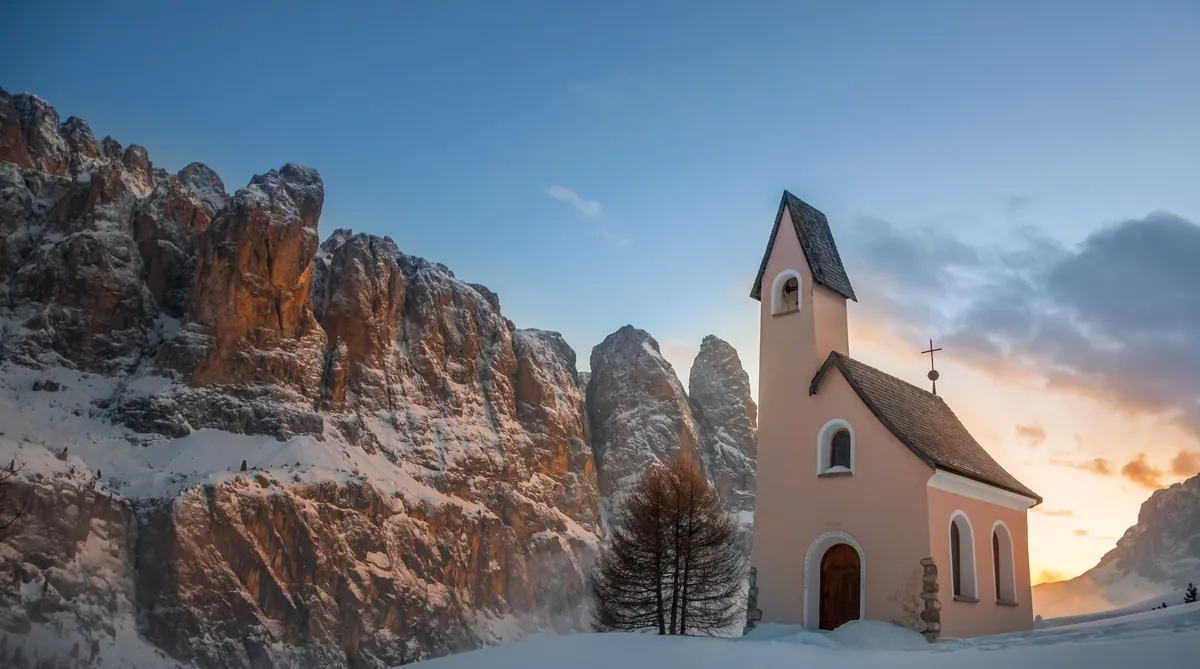 Kapelle am Grödner Joch vor verschneiten Felstürmen – Dolomiten, Südtirol