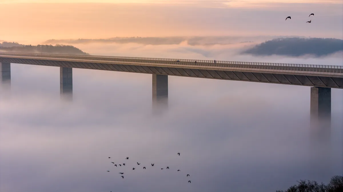 Kochertalbrücke über dem Nebelmeer mit Vogelschwarm bei Sonnenaufgang – Geislingen am Kocher