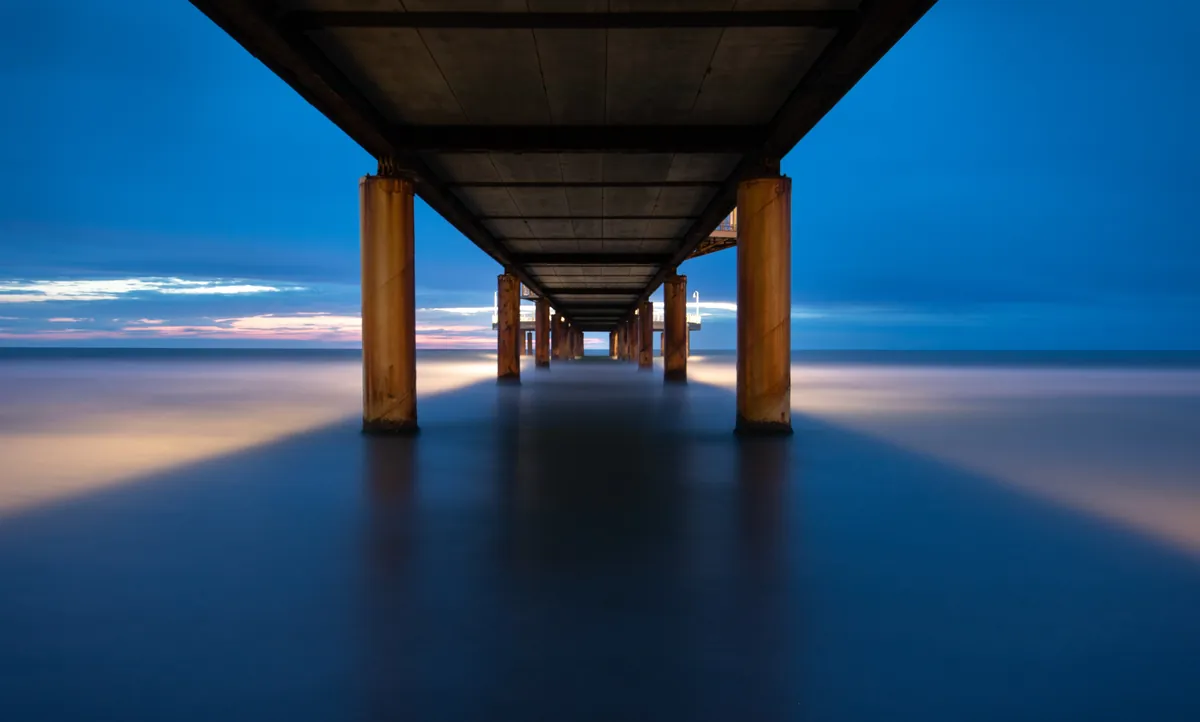 Blick unter der Seebrücke aufs Meer mit Langzeitbelichtung – Lido di Camaiore, Toskana